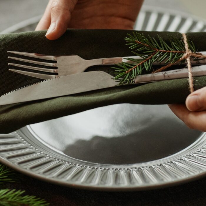 Woman Setting Elegant Plates on Christmas Table