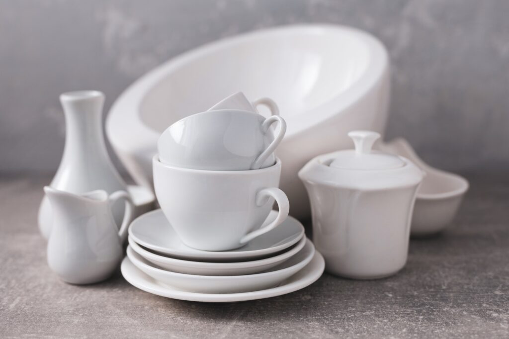 Empty crockery set or white ceramic dishes. White kitchen dishware and tableware on table
